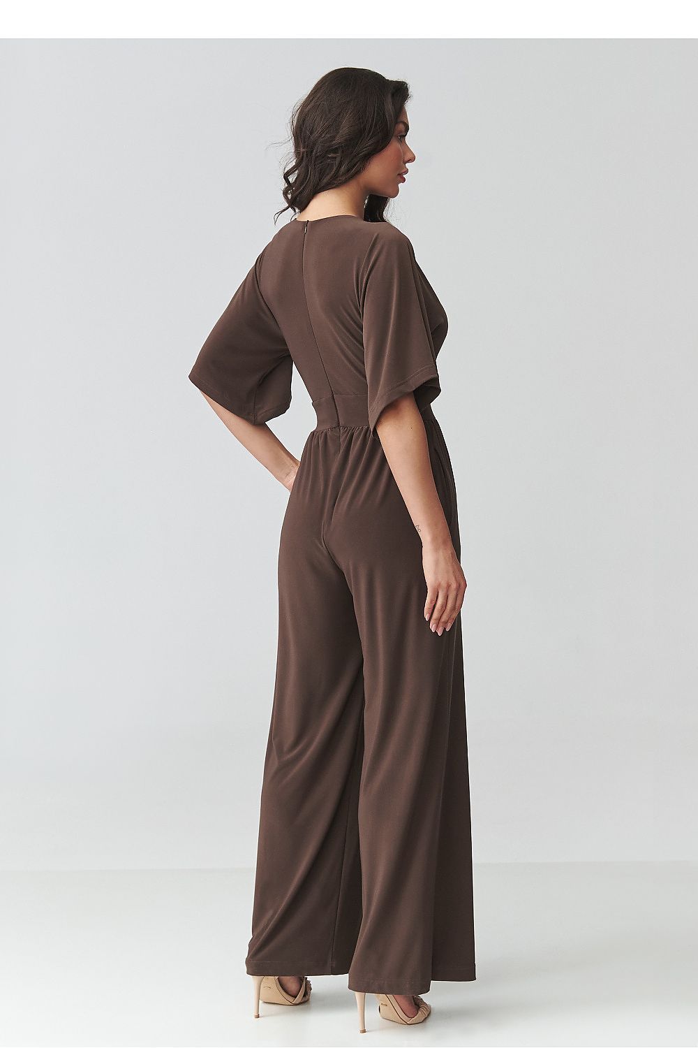 Woman wearing a brown jumpsuit on a white background