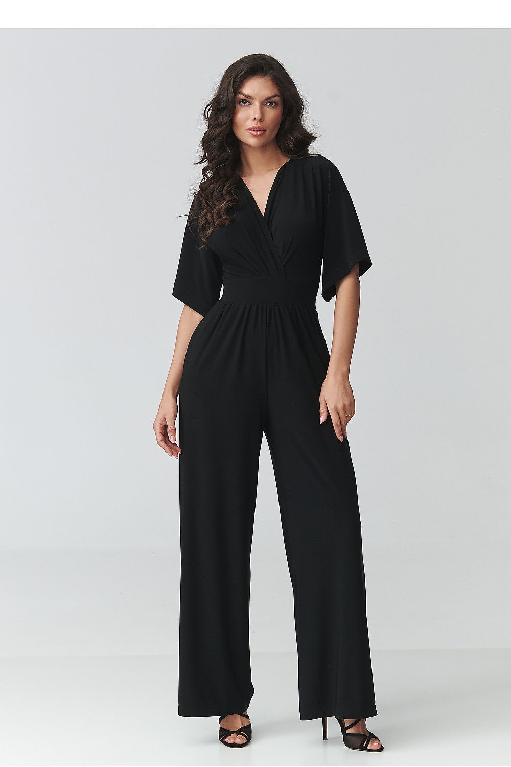 Woman wearing a black jumpsuit on a white background