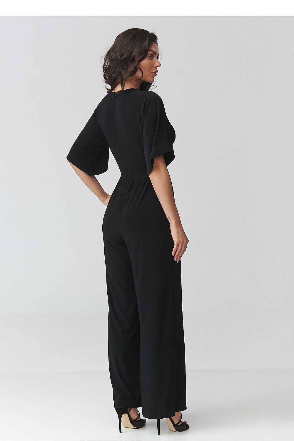 Woman wearing a black jumpsuit on a white background