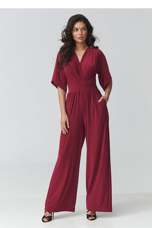 Woman wearing a burgundy jumpsuit on a white background