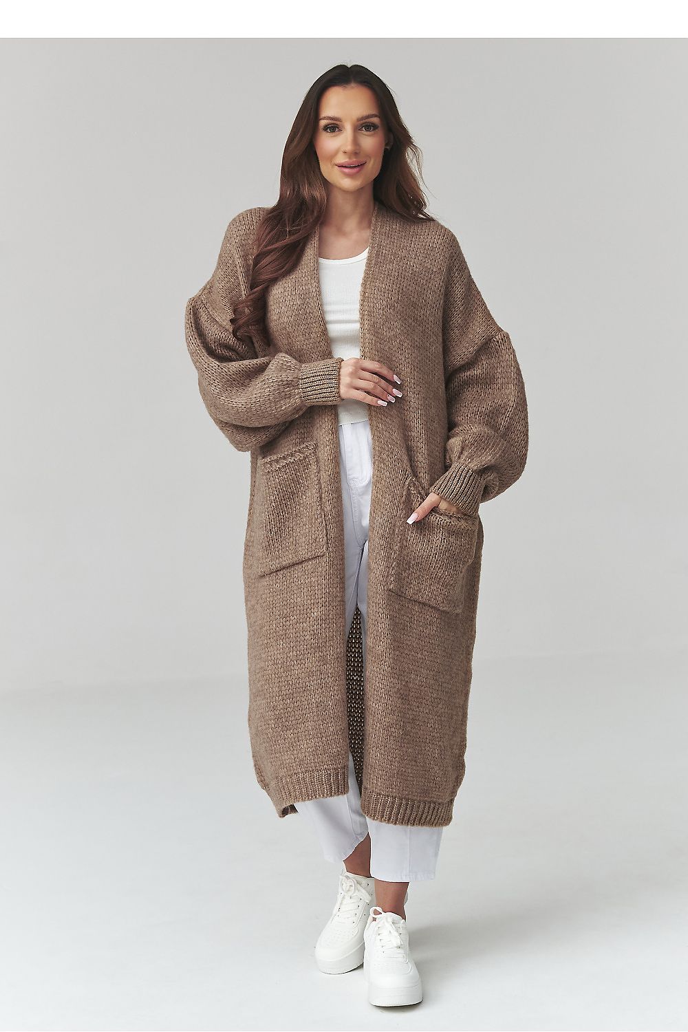 Woman wearing a long brown cardigan on a white background
