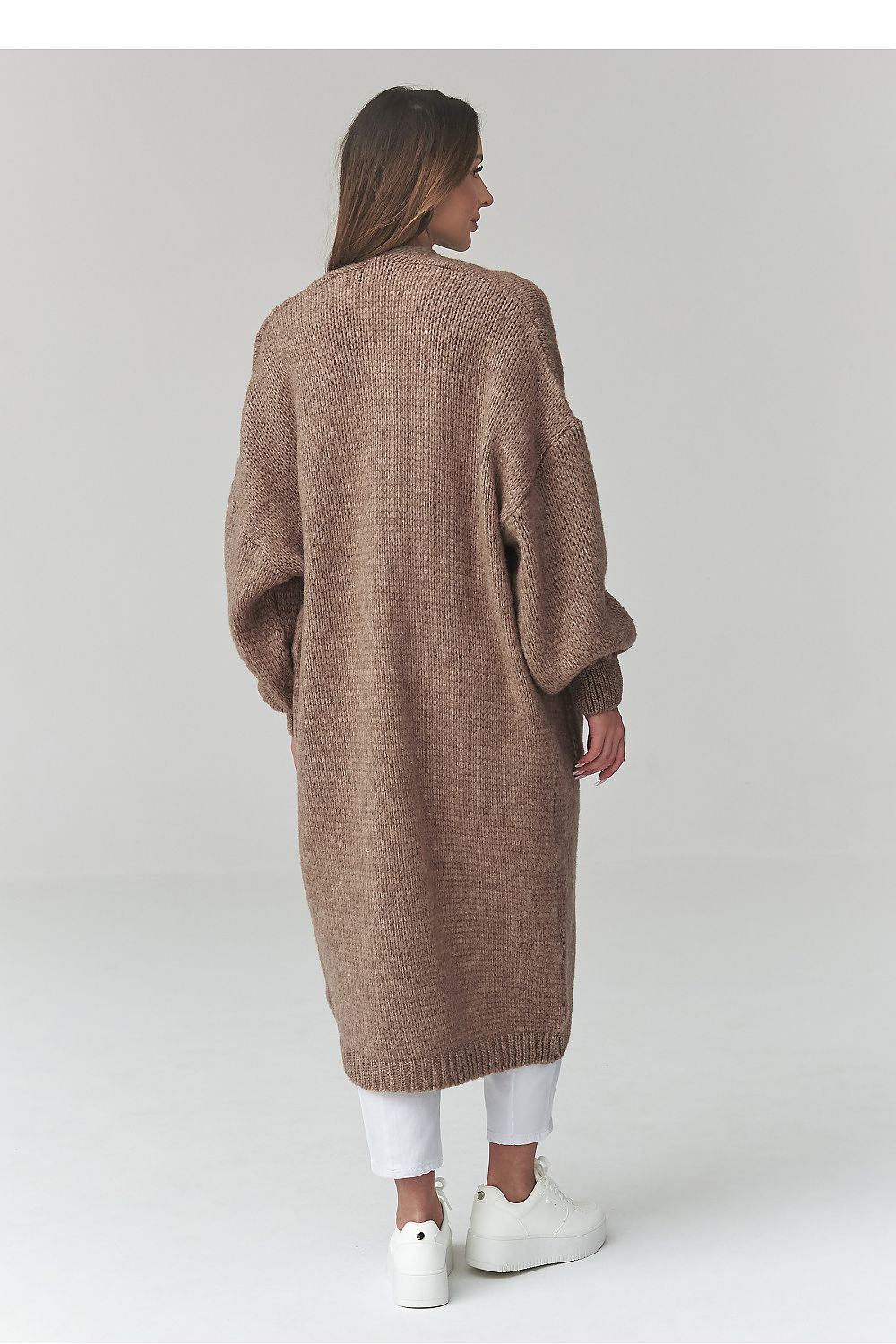Woman wearing a long brown cardigan on a white background