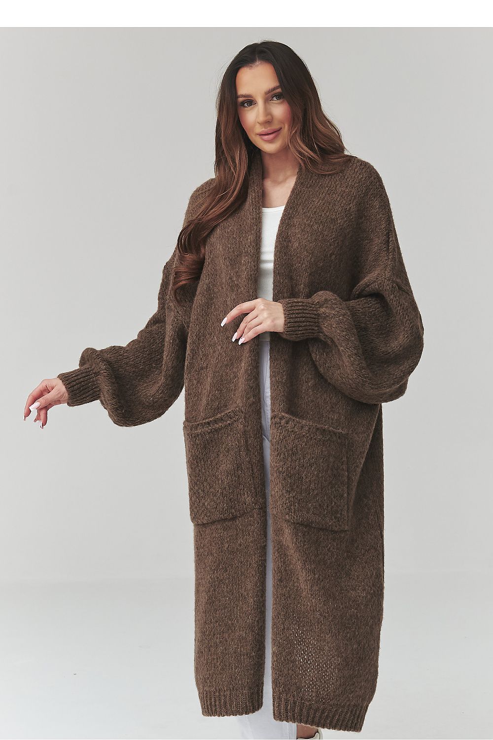Woman wearing a brown long cardigan on a light gray background