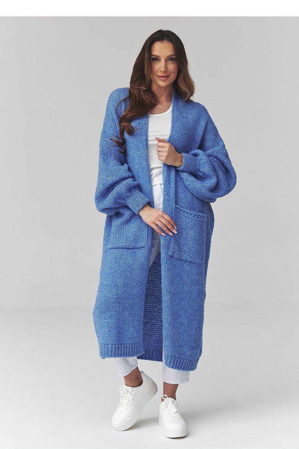 Woman wearing a blue knitted cardigan on a white background