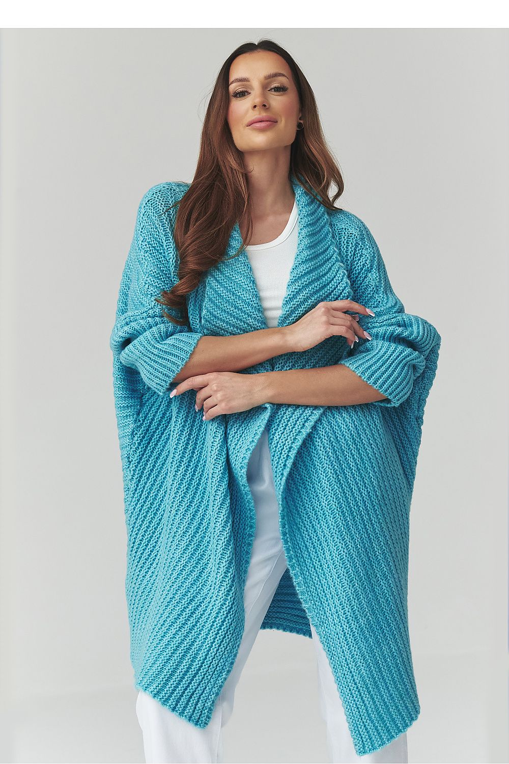 Woman wearing a blue knitted shawl on a white background