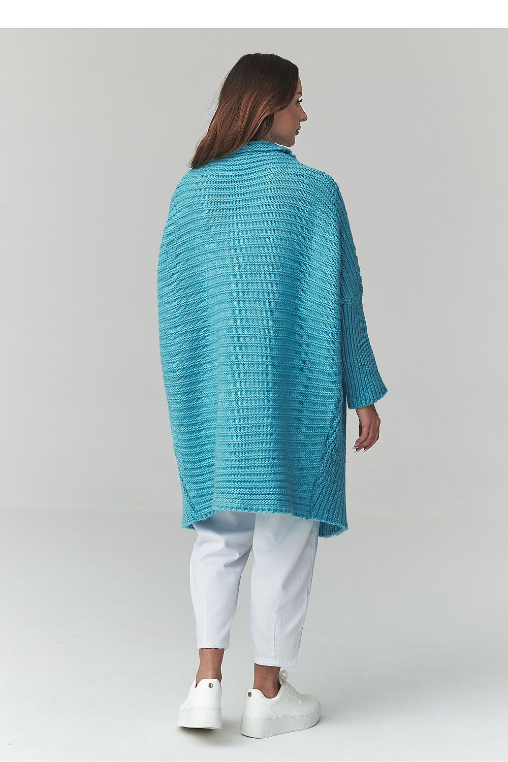 Woman wearing a blue knitted cardigan on a white background