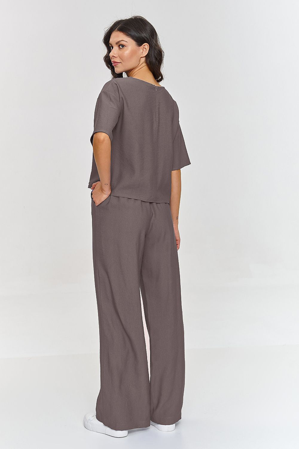 Woman wearing a brown outfit on a white background