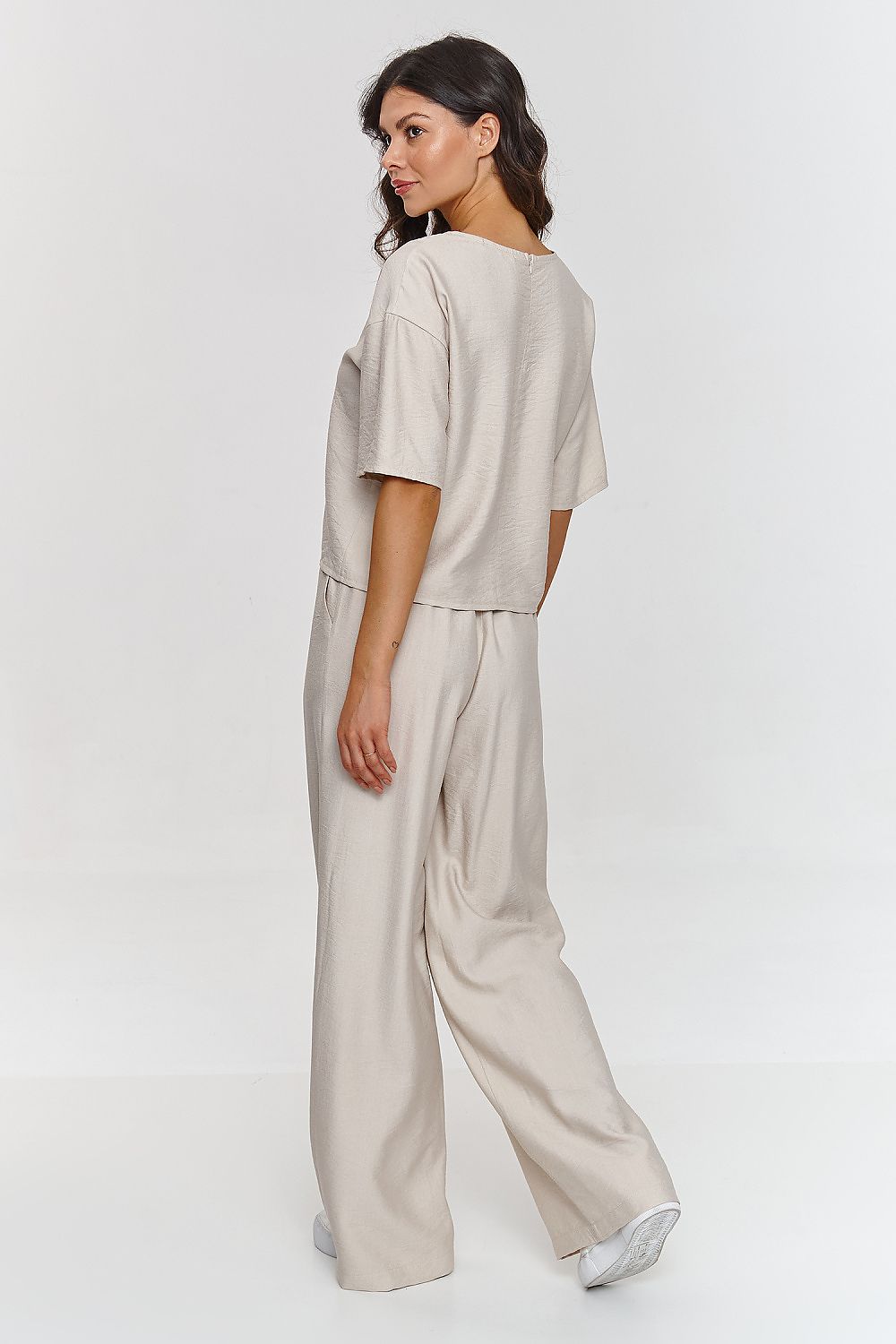 Woman wearing a beige outfit on a white background
