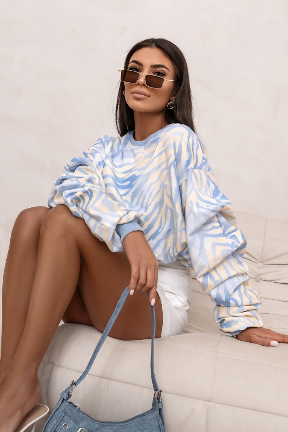 Woman wearing a blue and white striped sweater sitting on a couch.