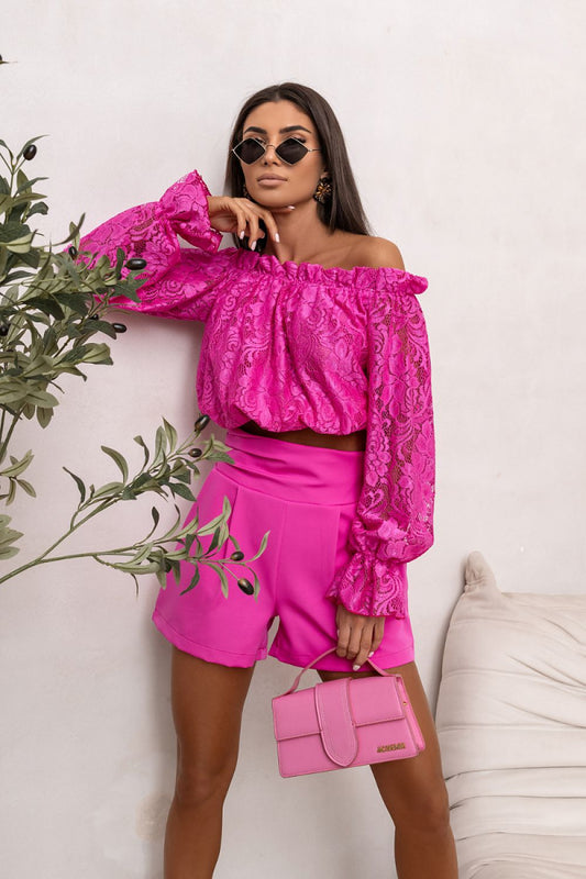 Woman wearing a bright pink outfit with matching accessories against a white background