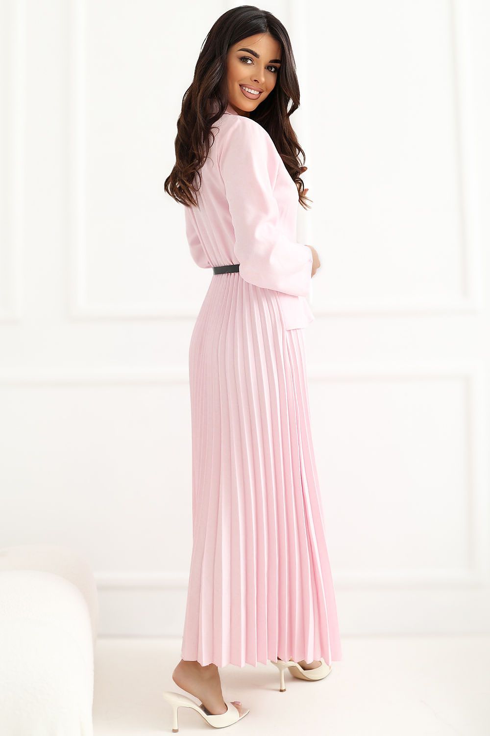 Woman wearing a pink pleated dress on a white background
