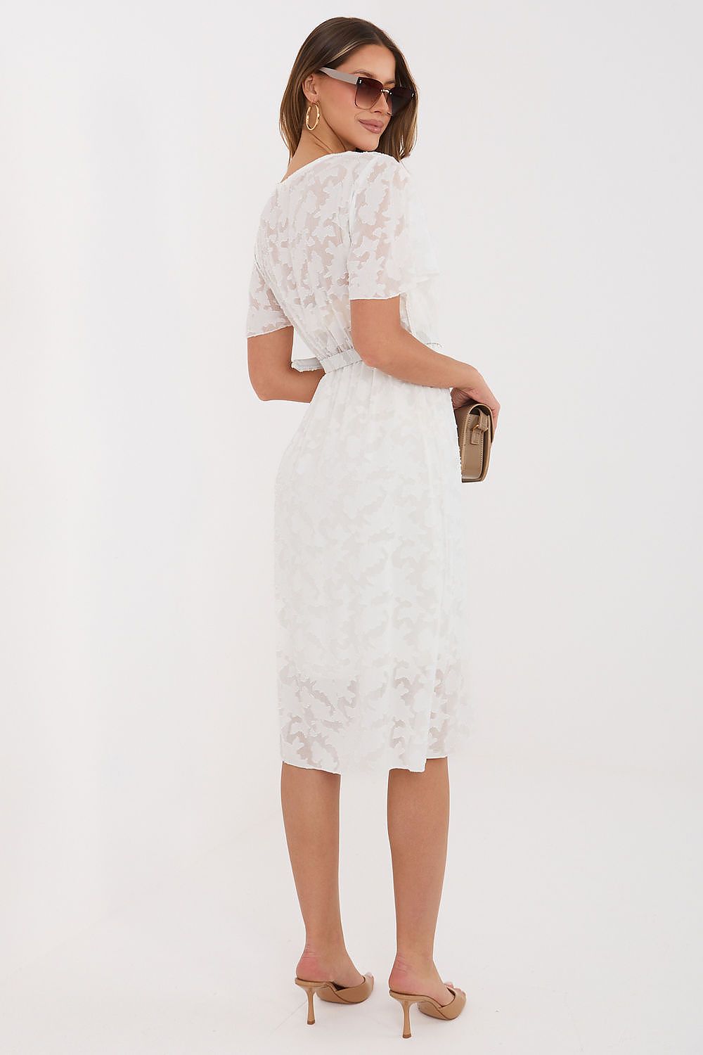 Woman wearing a white lace dress on a white background