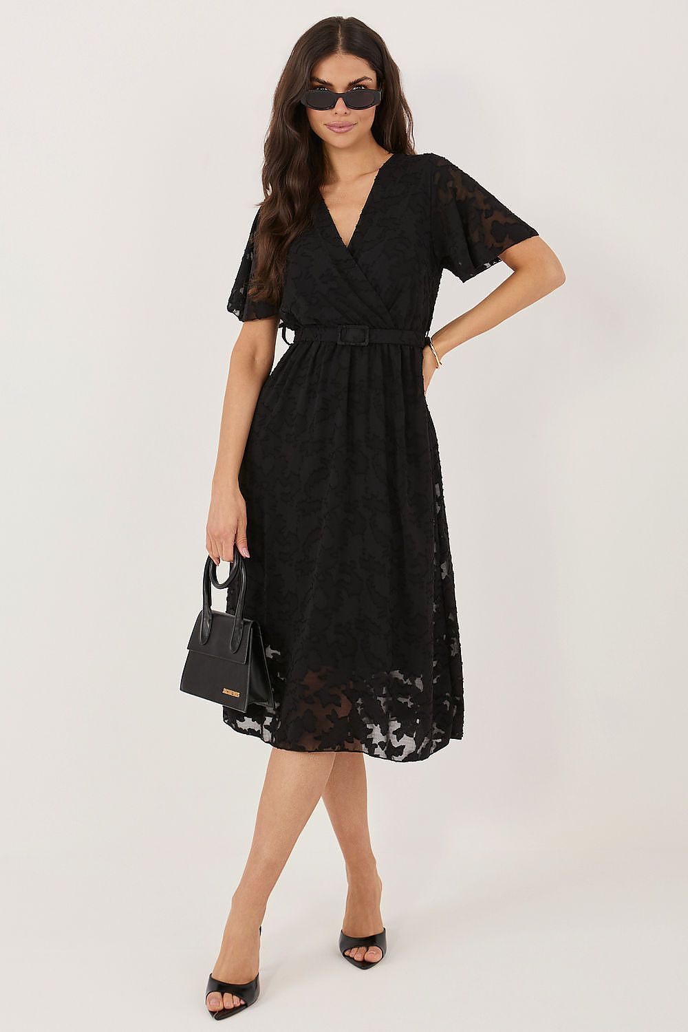 Woman wearing a black lace dress on a white background