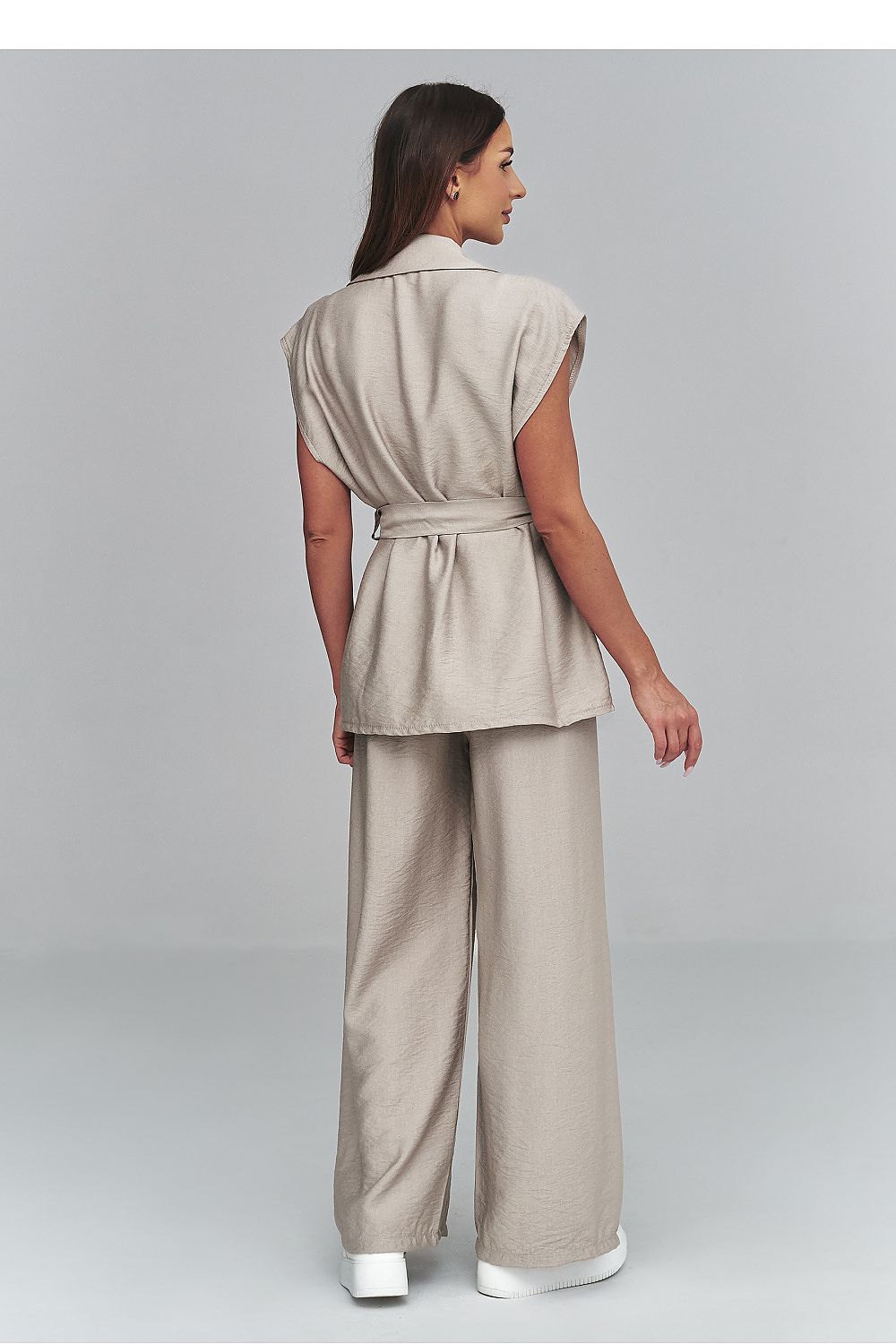Woman wearing a beige suit on a plain background
