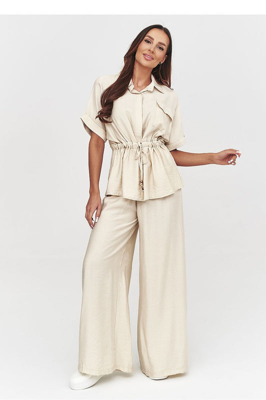 Woman wearing a beige outfit with wide-leg pants on a white background