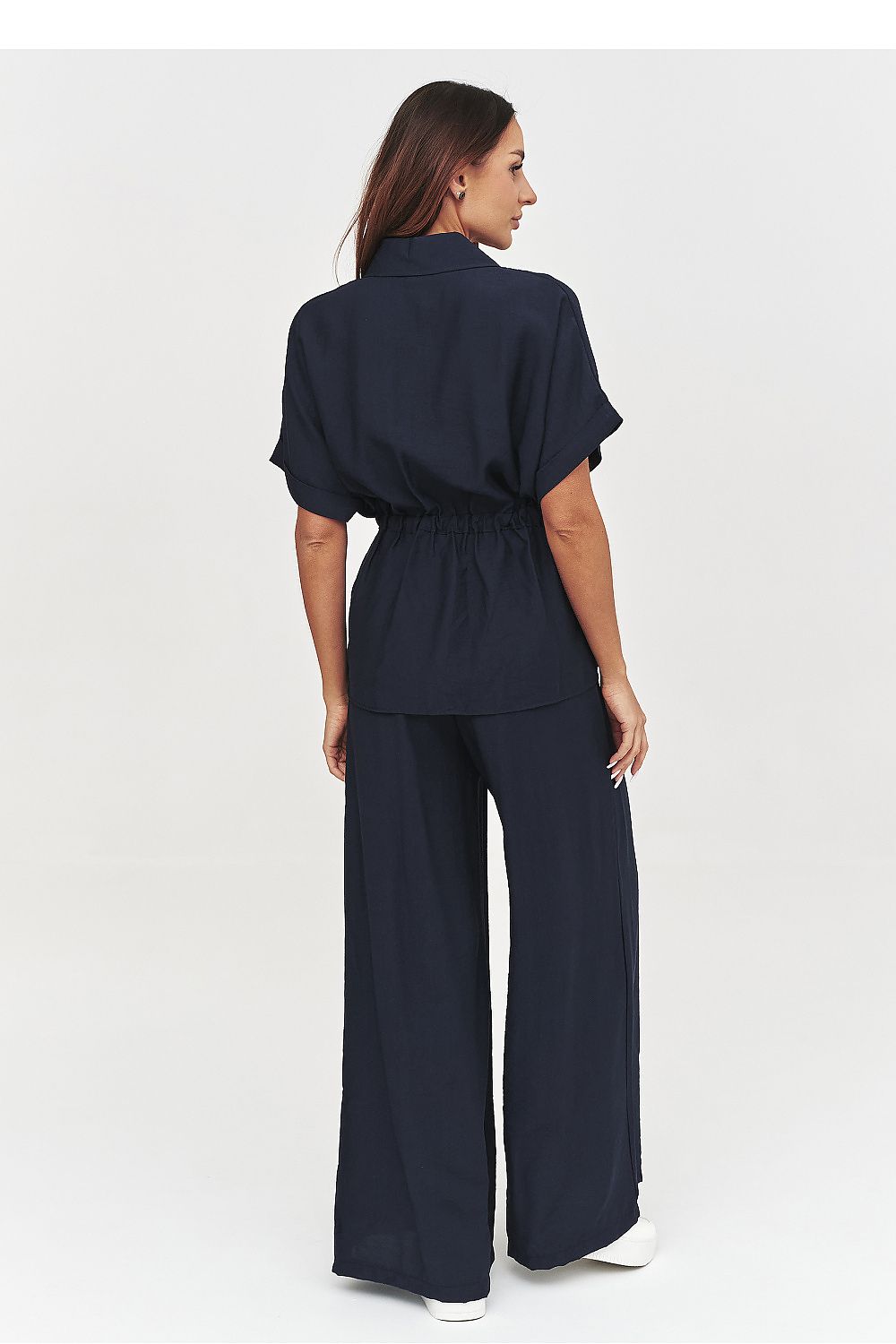 Woman wearing a navy blue outfit on a white background
