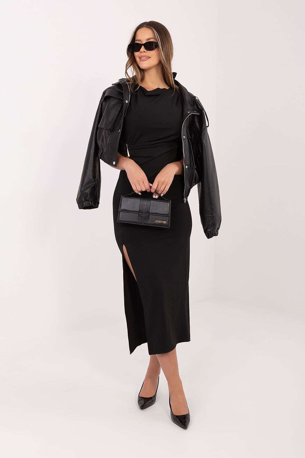 Woman in a black outfit with a leather jacket and black shoes on a white background