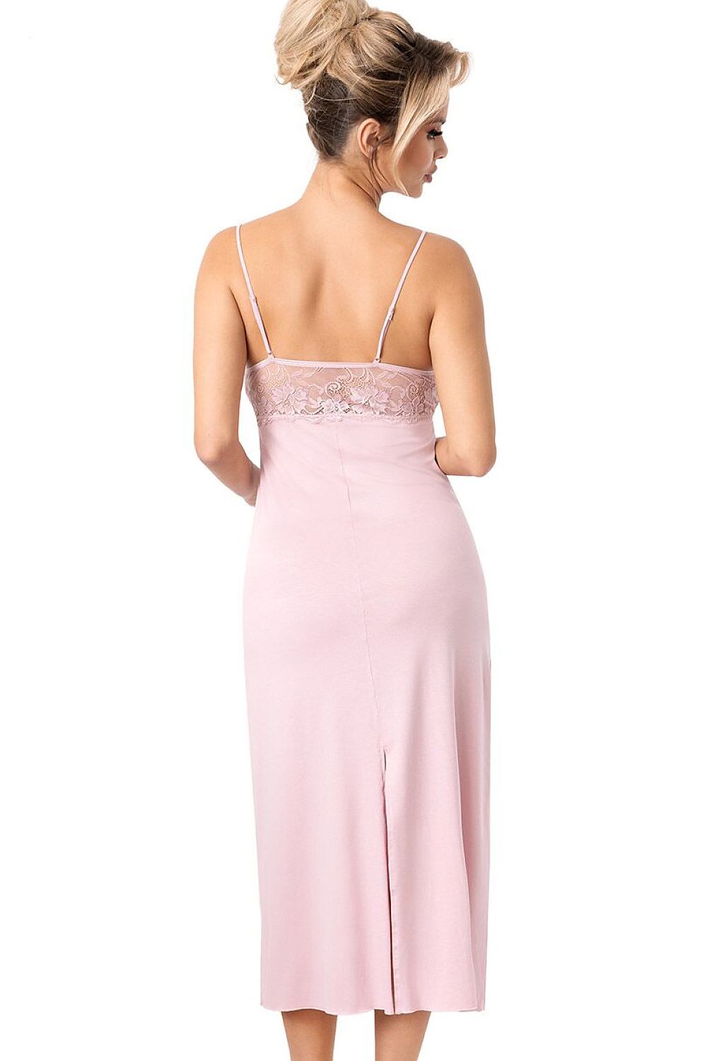 Woman wearing a pink slip dress with lace detailing on a white background