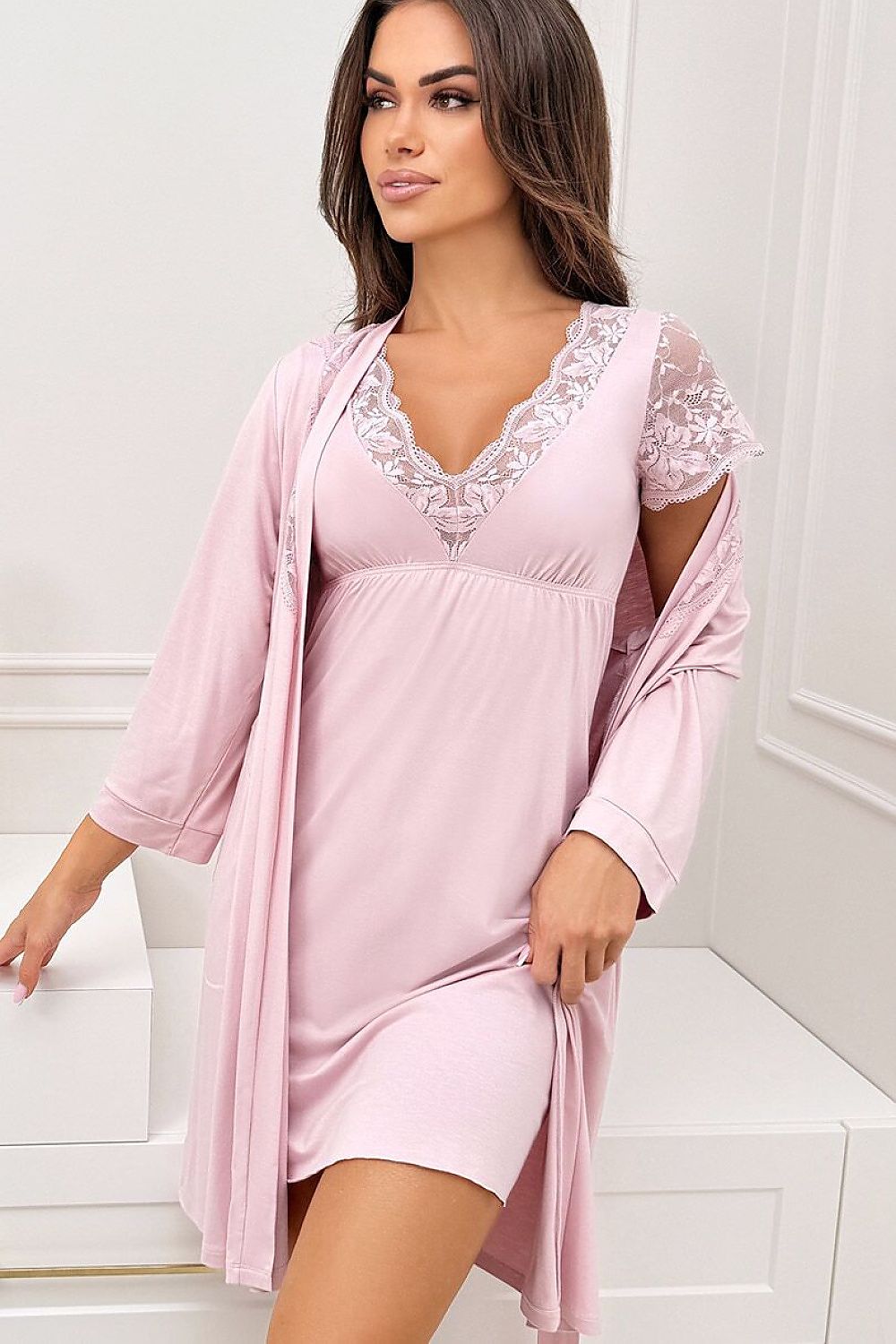 Woman wearing a pink lace nightgown with matching robe in a bathroom setting