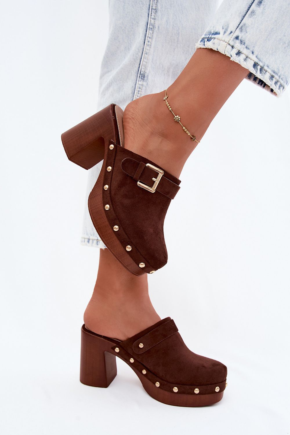 Brown suede clogs with buckles on a white background