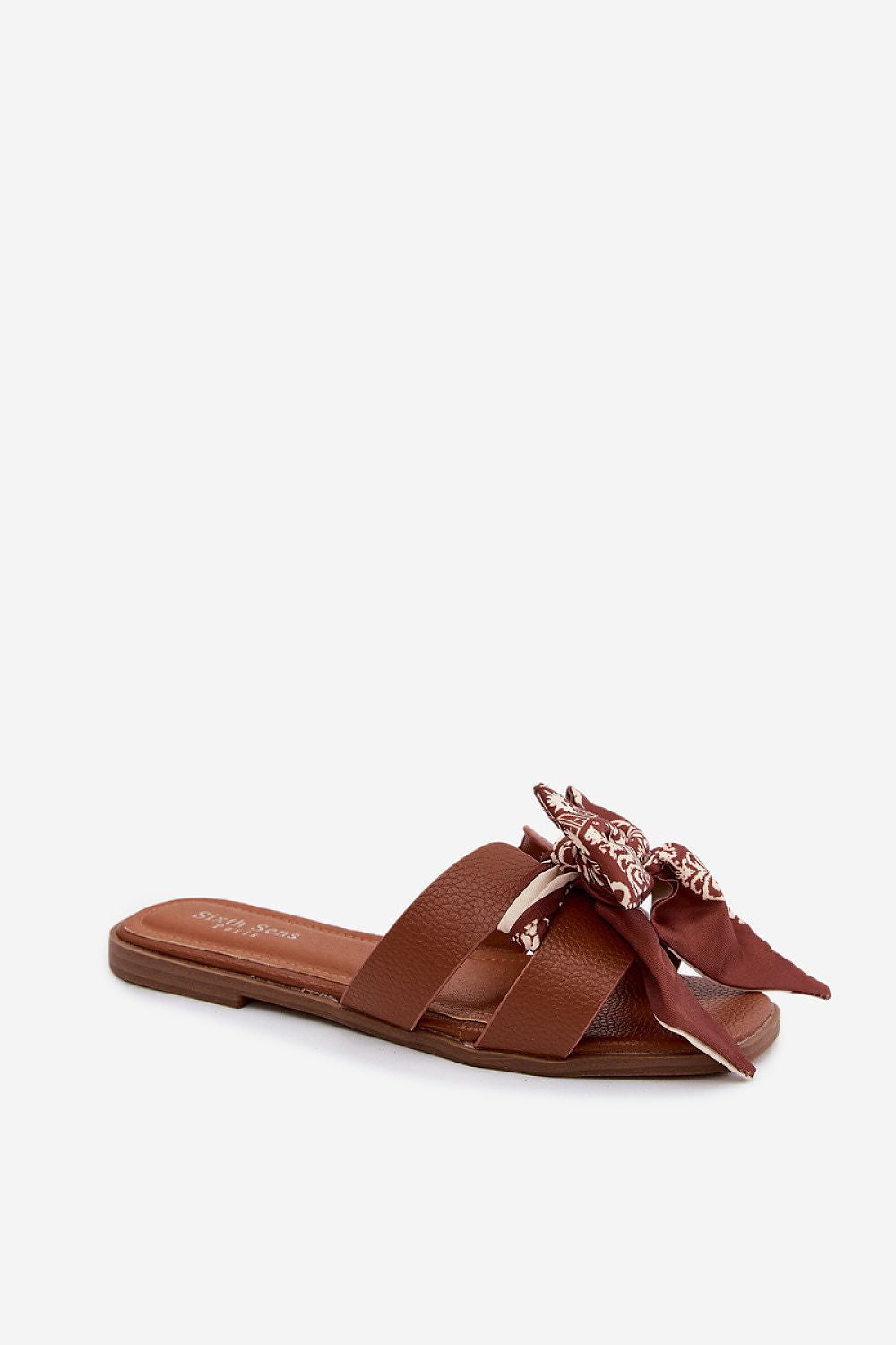 Brown sandal with bow detail on a white background
