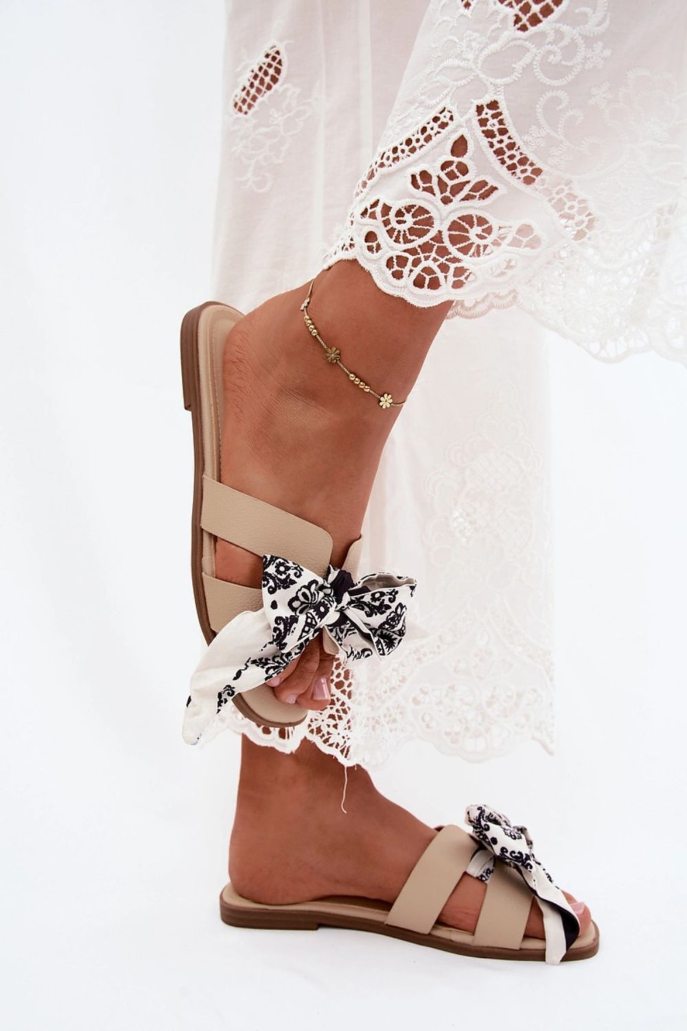  Beige flat sandals featuring oversized bow detail and feminine styling