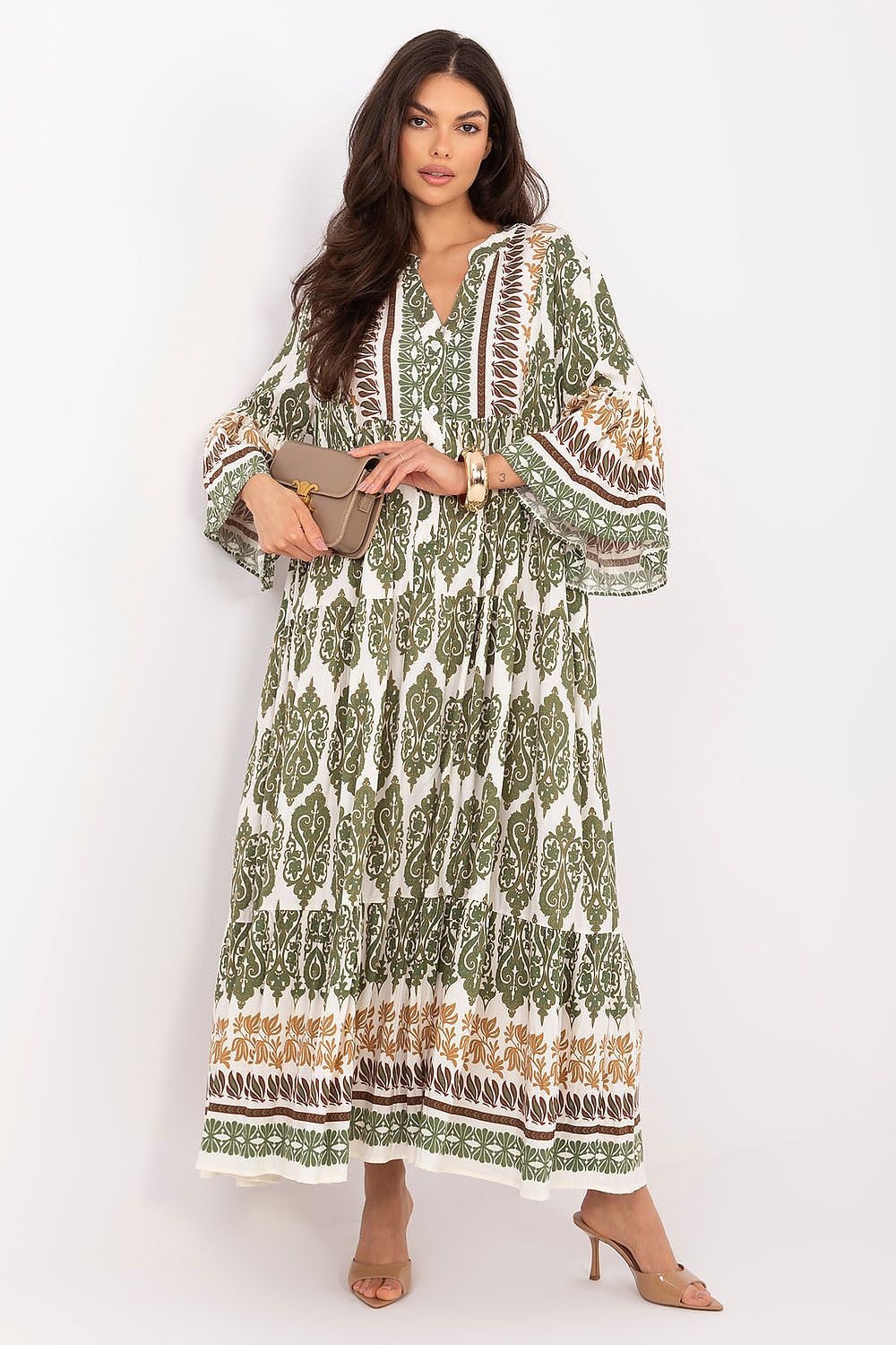 Woman wearing a green patterned dress on a white background
