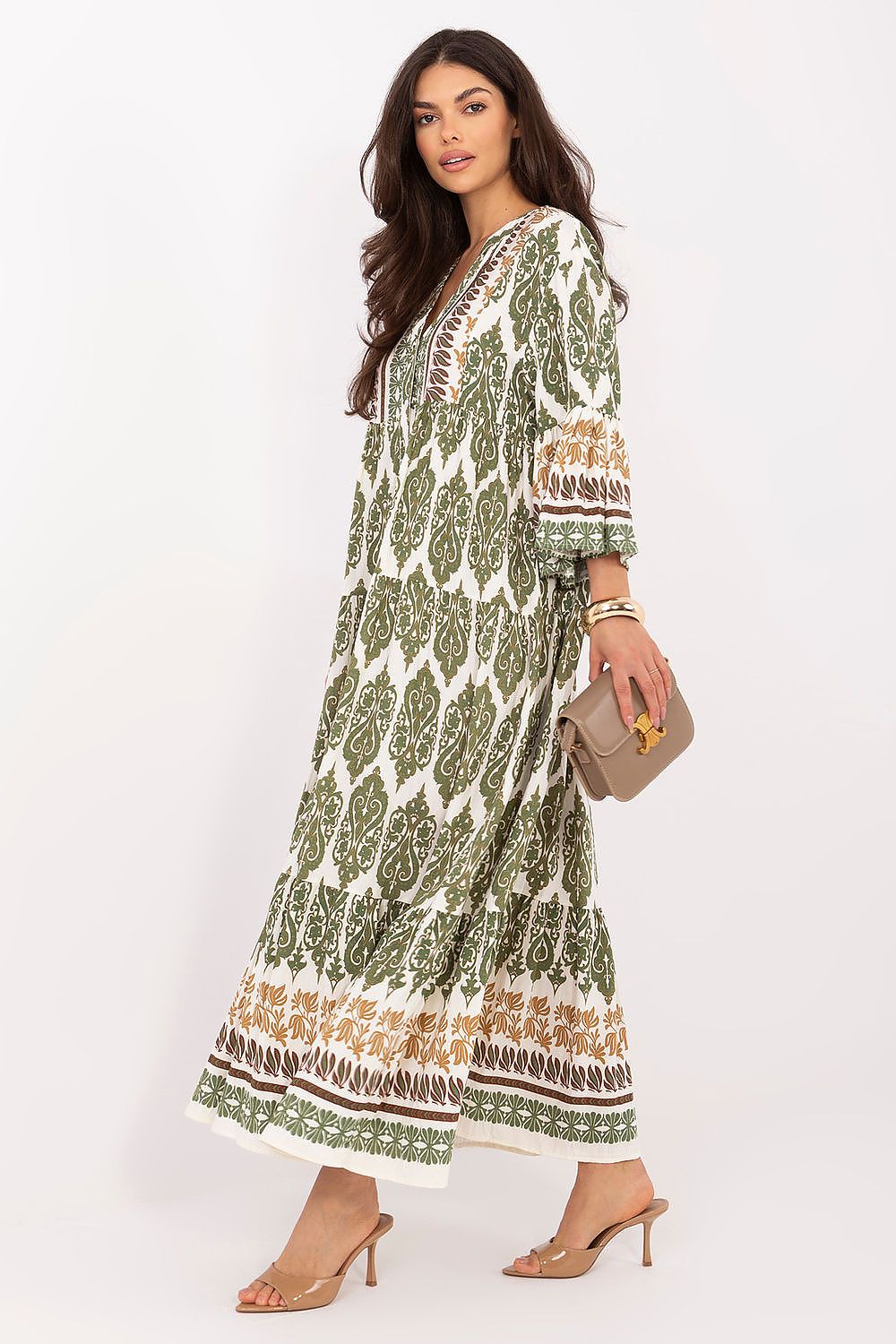 Woman wearing a green and white patterned dress on a white background