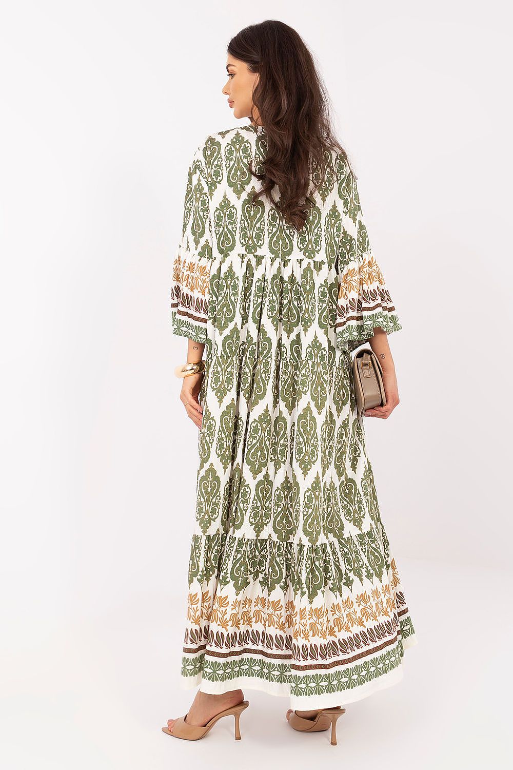 Woman wearing a green and white patterned dress on a white background