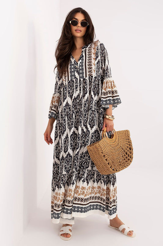 Woman wearing a patterned dress holding a straw bag on a white background
