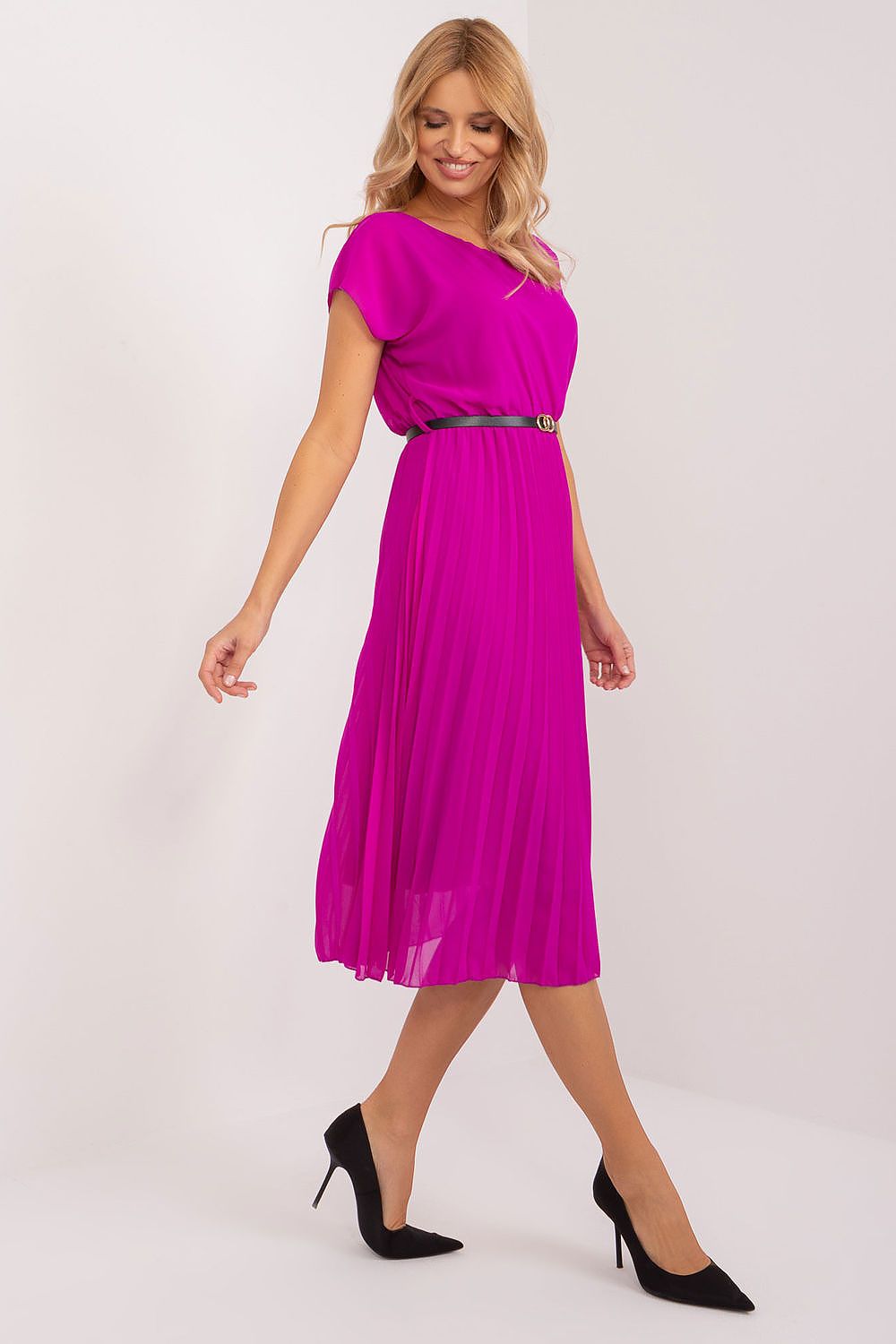 Woman wearing a bright pink dress with a belt on a white background