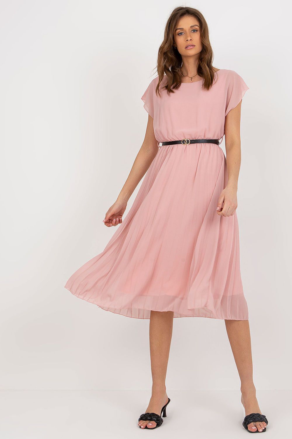Woman wearing a pink dress with a belt on a white background