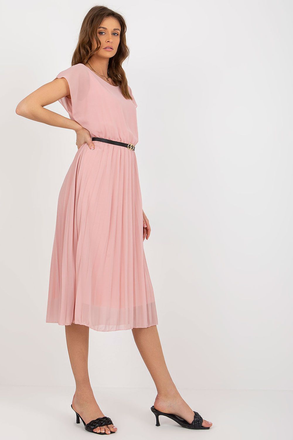 Woman wearing a pink dress with a belt on a white background