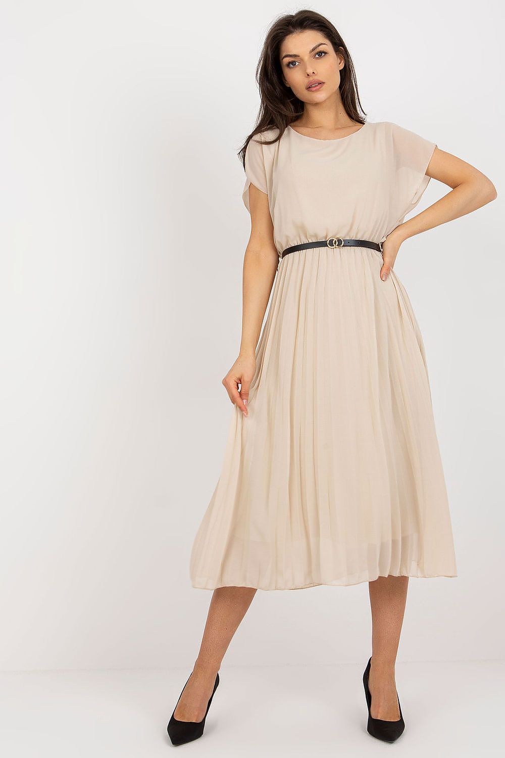 Woman wearing a beige dress with a belt on a white background