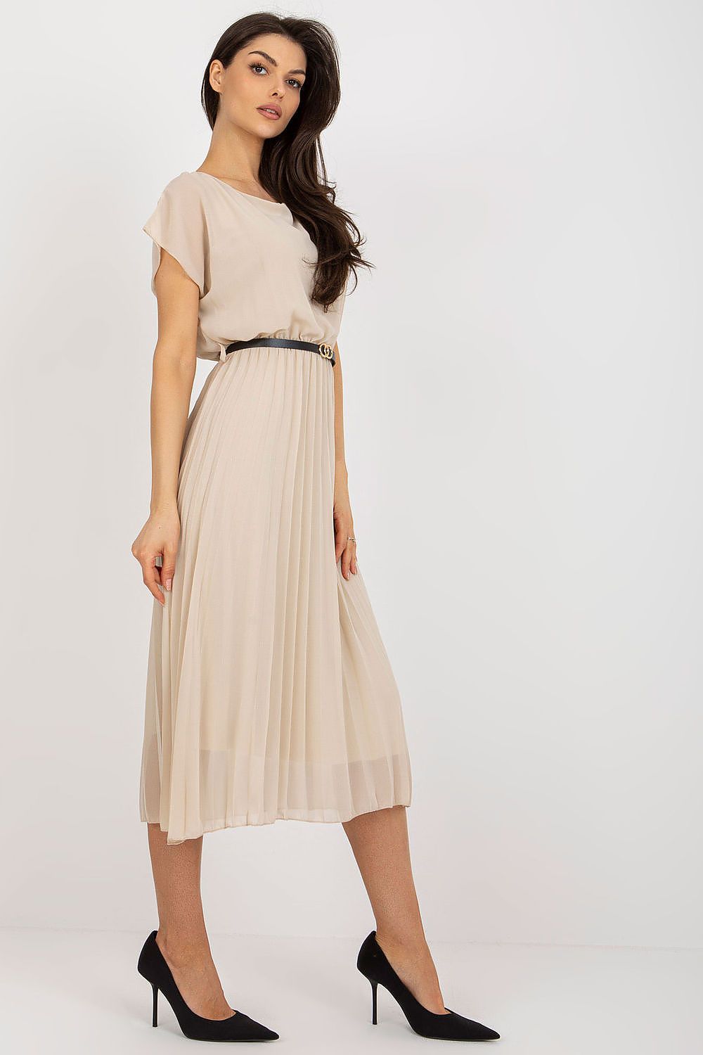 Woman wearing a beige dress with a belt on a white background