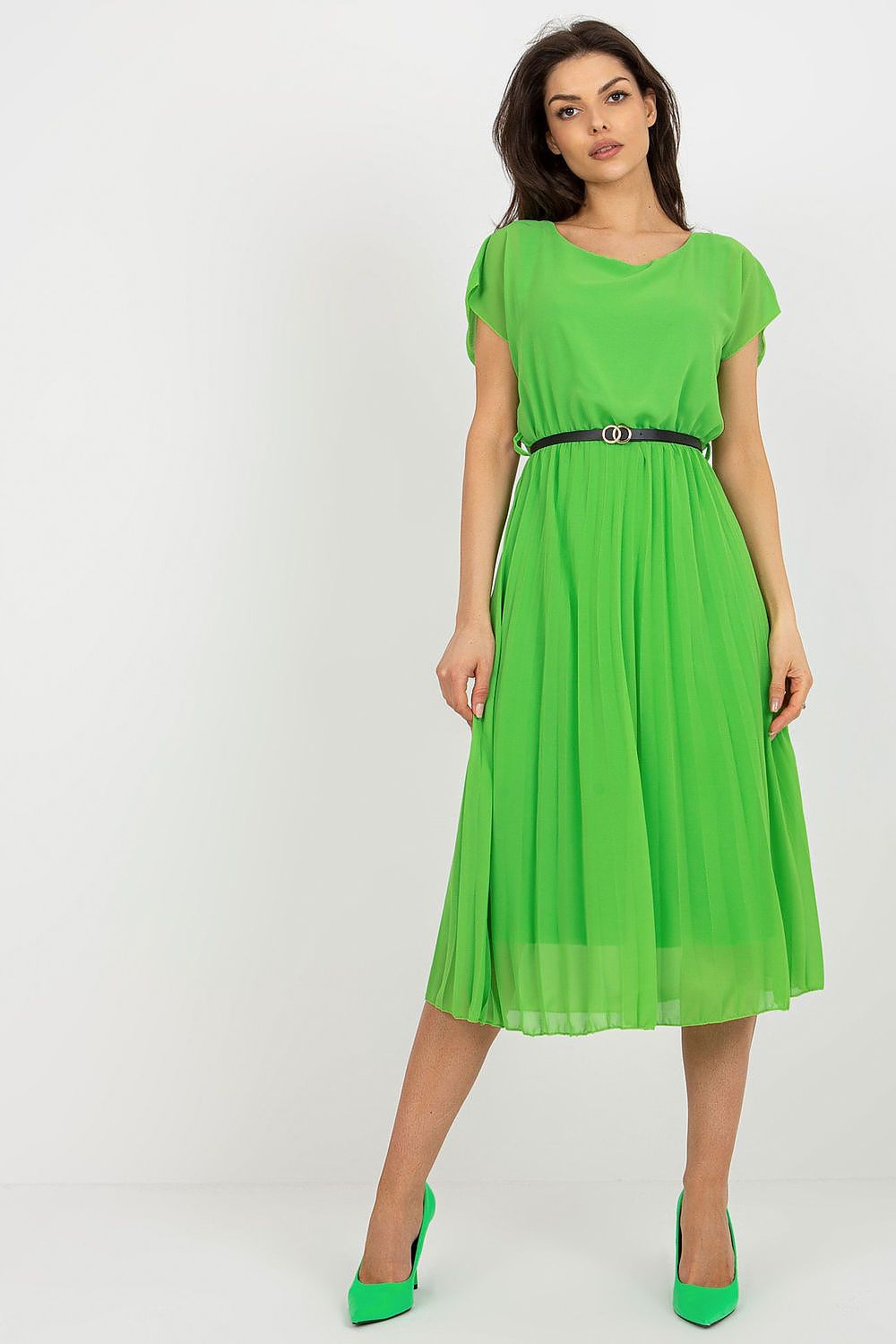 Woman wearing a green dress with a belt on a white background