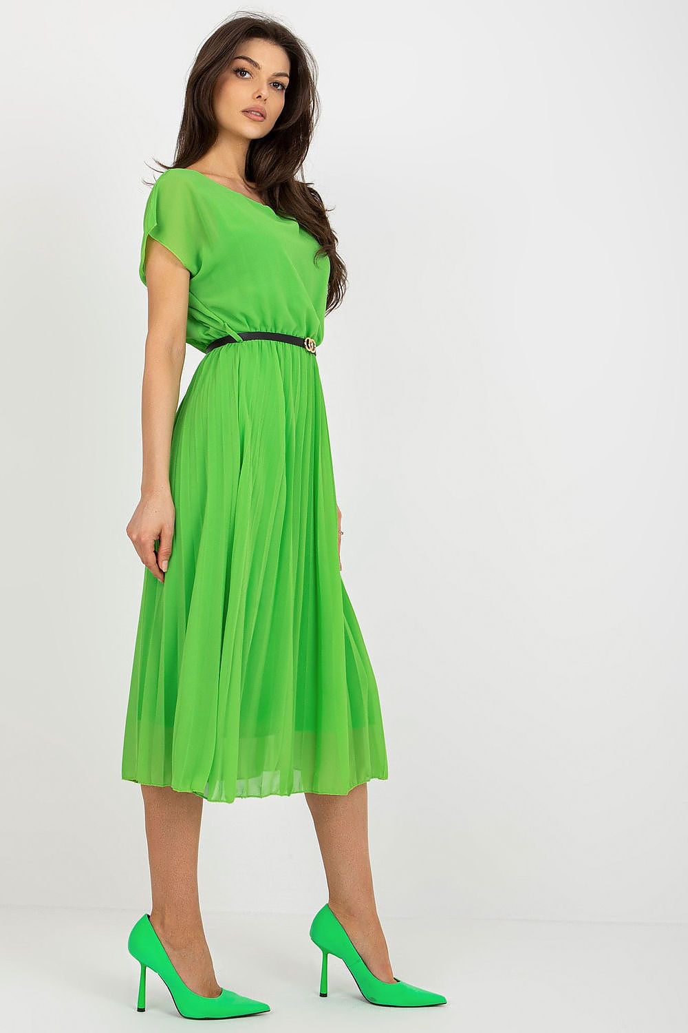Woman wearing a green dress with a belt on a white background