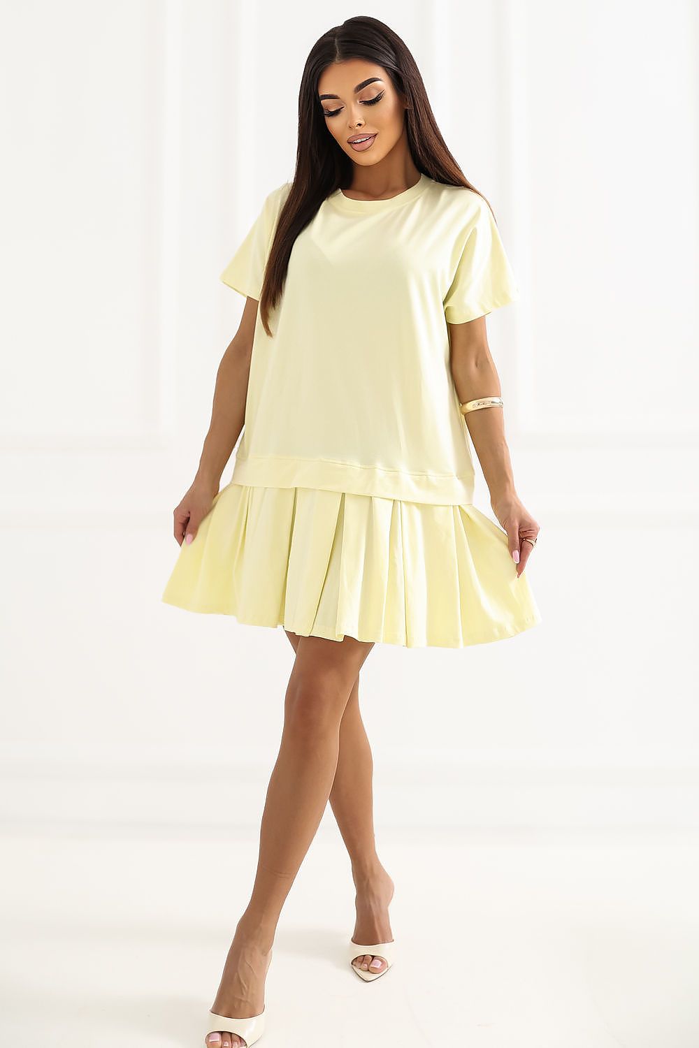 Woman wearing a light yellow dress on a white background