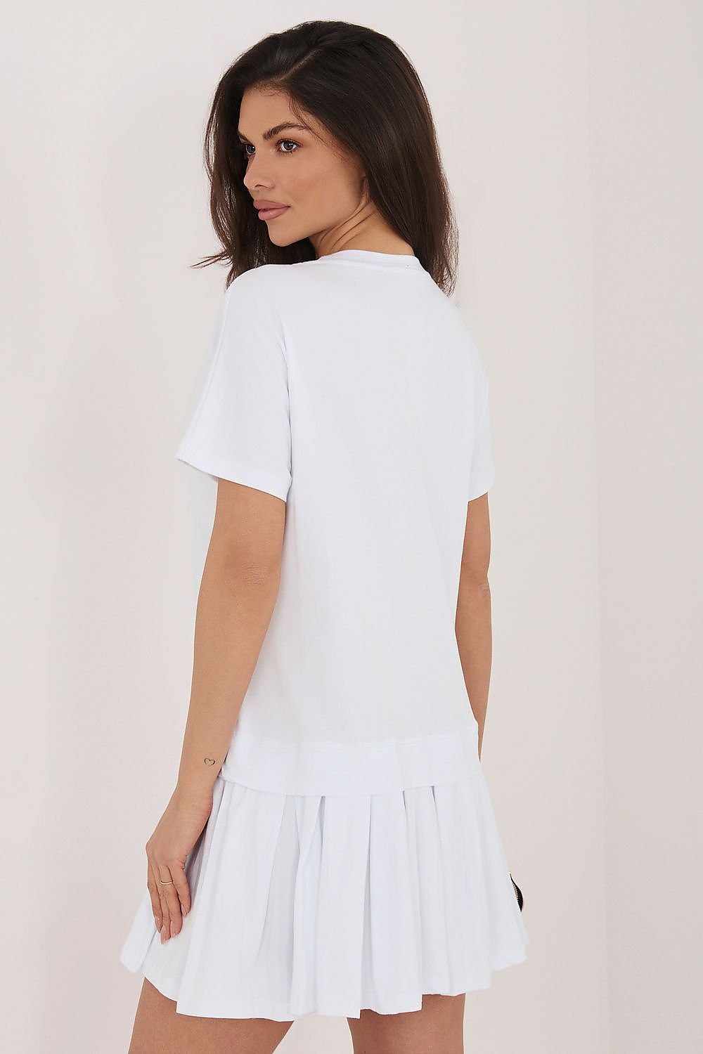 Woman wearing a white dress against a plain background