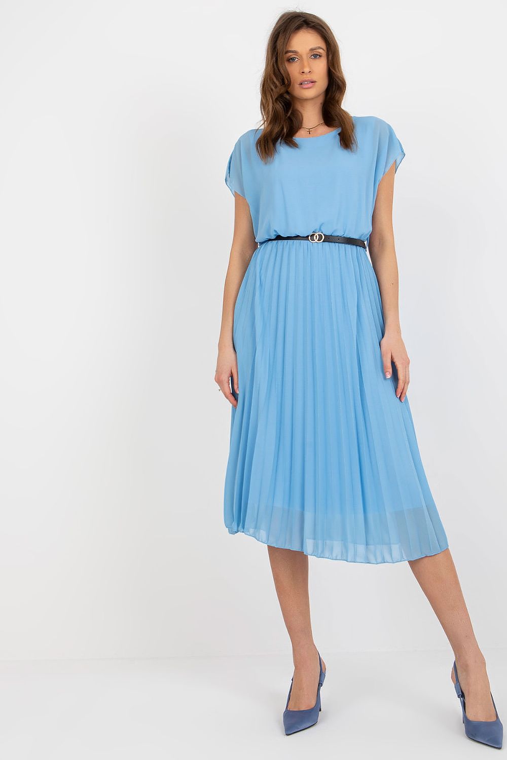 Woman wearing a light blue dress with a belt on a white background
