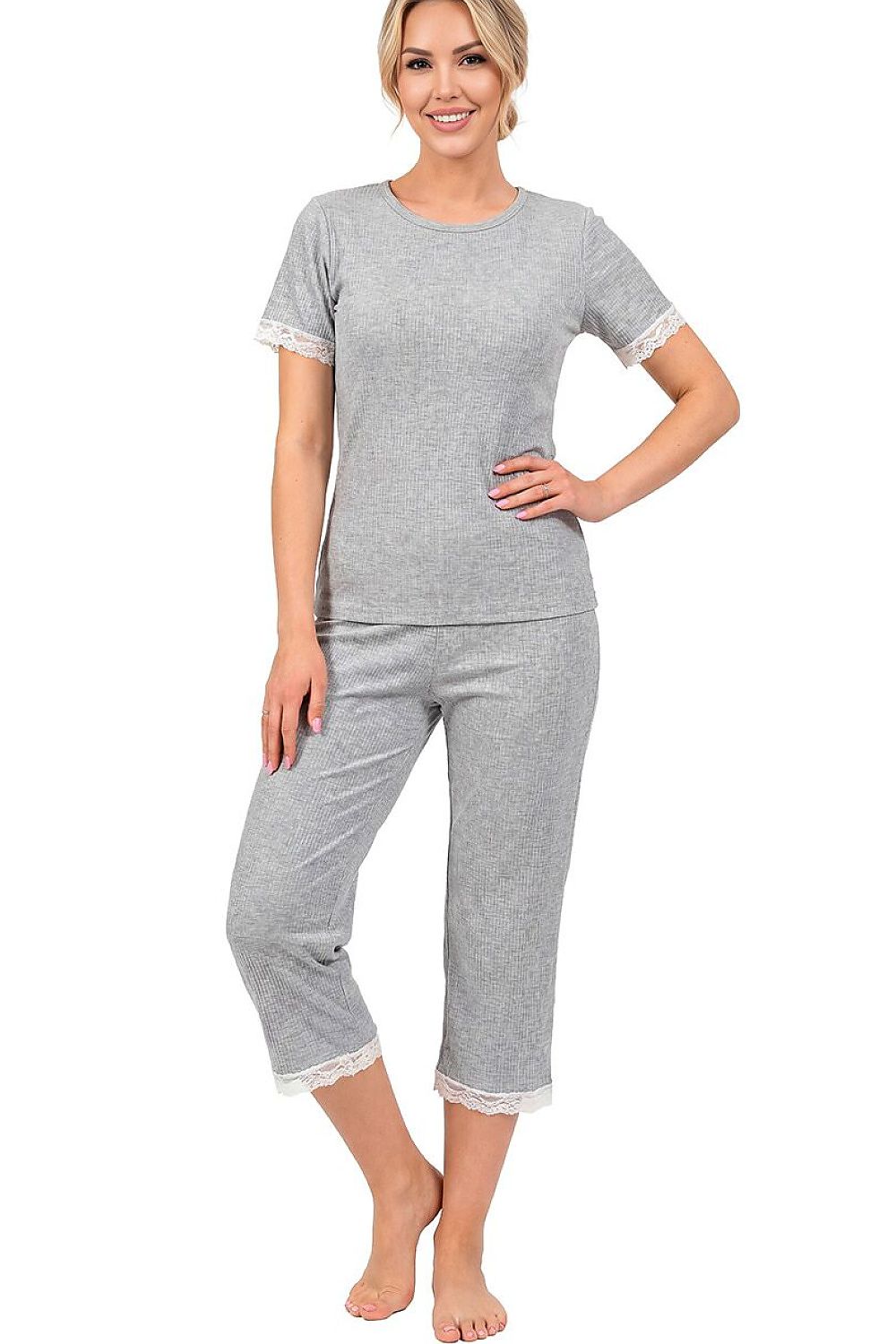 Woman wearing a gray pajama set with lace trim on a white background