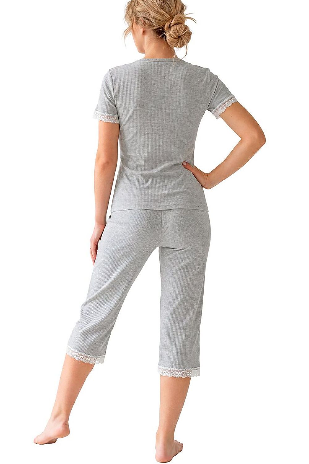 Woman wearing a gray outfit with lace trim on a white background