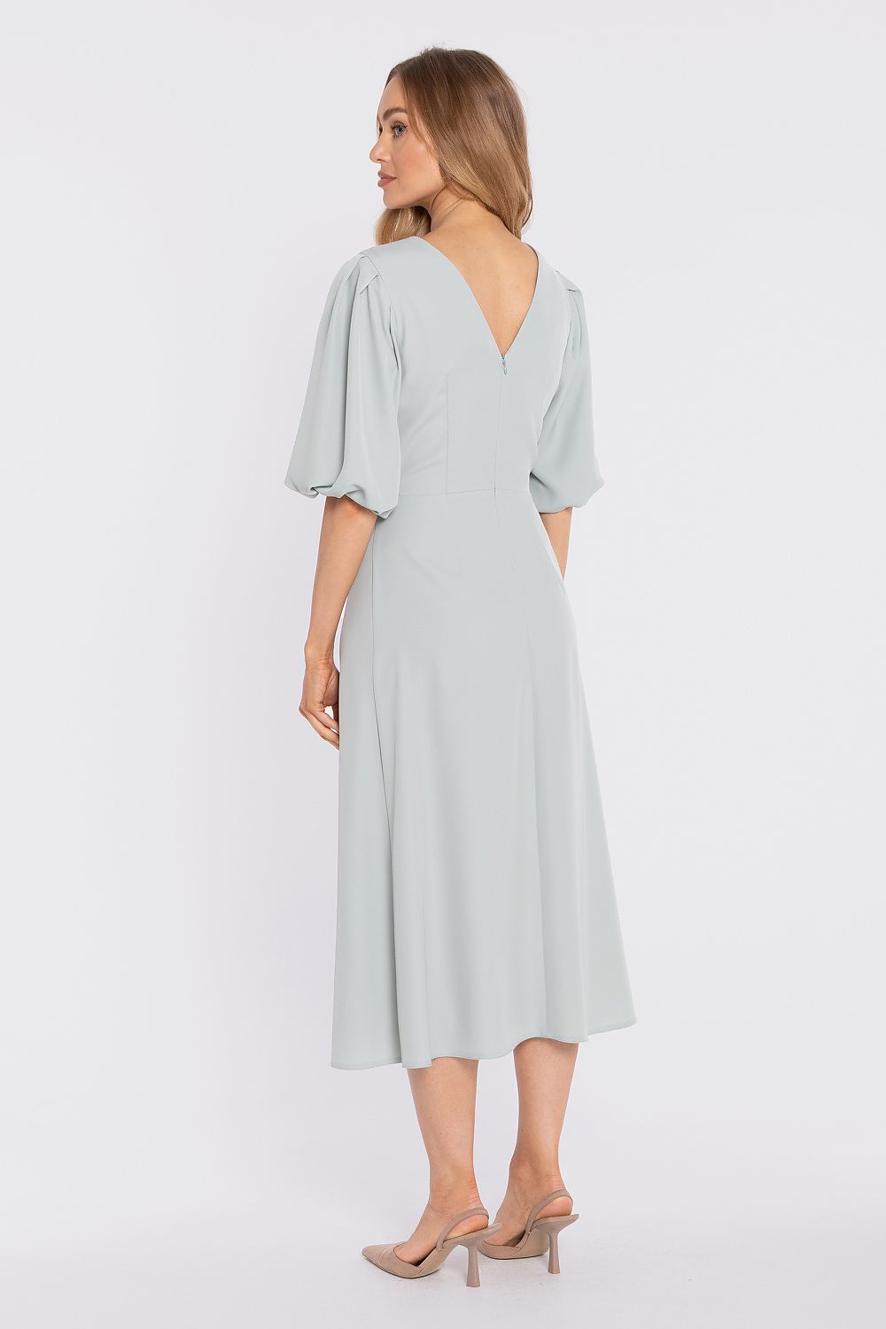 Woman wearing a light blue dress on a white background