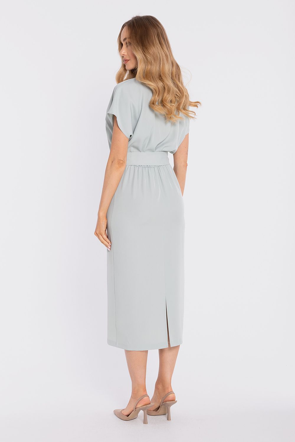 Woman wearing a light gray dress on a white background