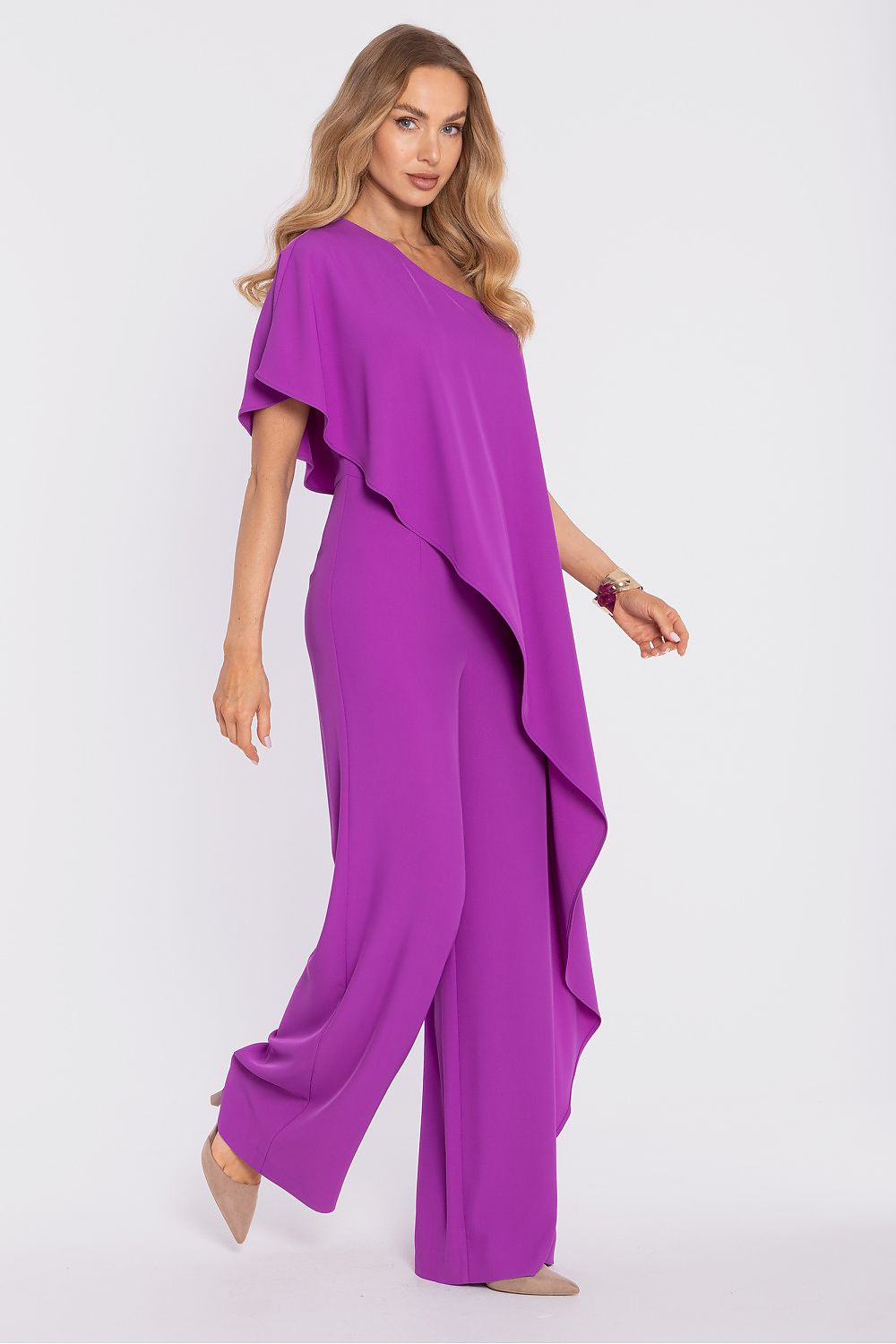 Woman wearing a vibrant purple jumpsuit on a white background