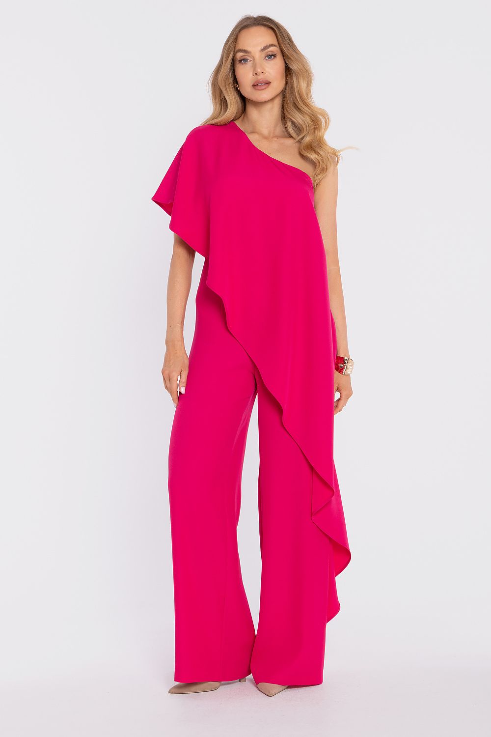 Woman wearing a bright pink jumpsuit on a white background