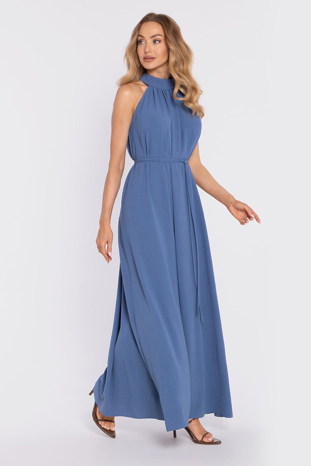 Woman wearing a blue sleeveless dress on a white background