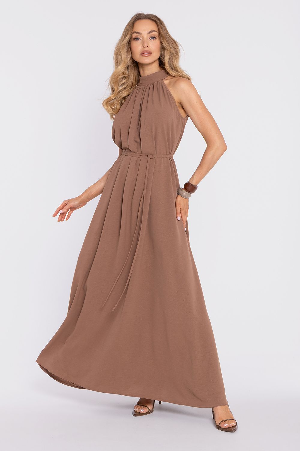 Woman wearing a brown halter neck dress on a white background