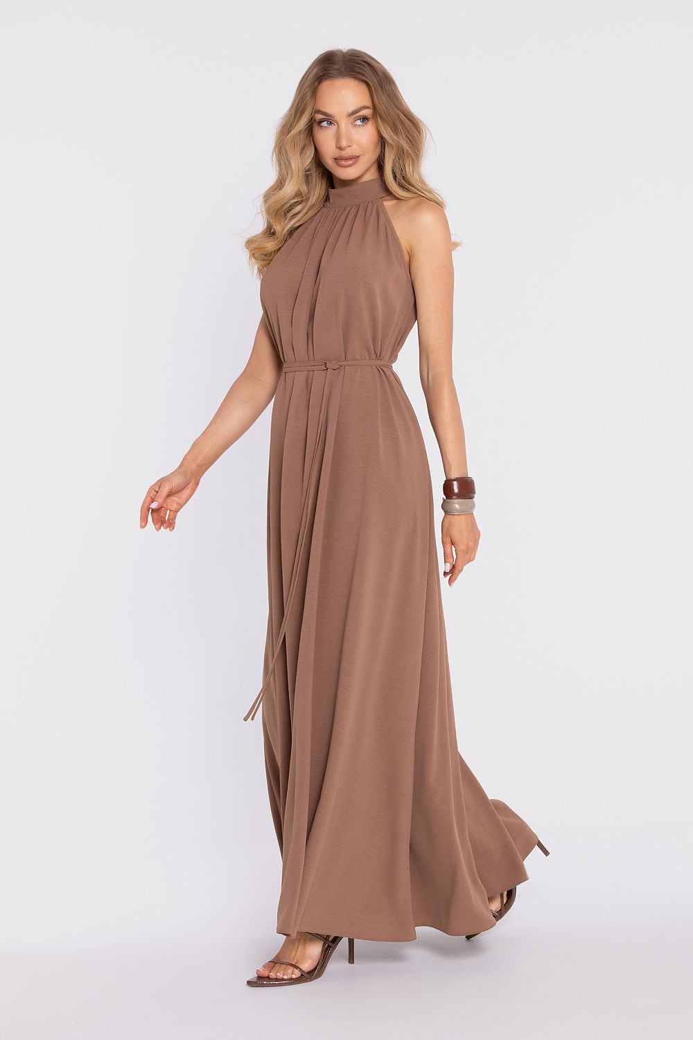 Woman wearing a brown halter neck dress on a white background