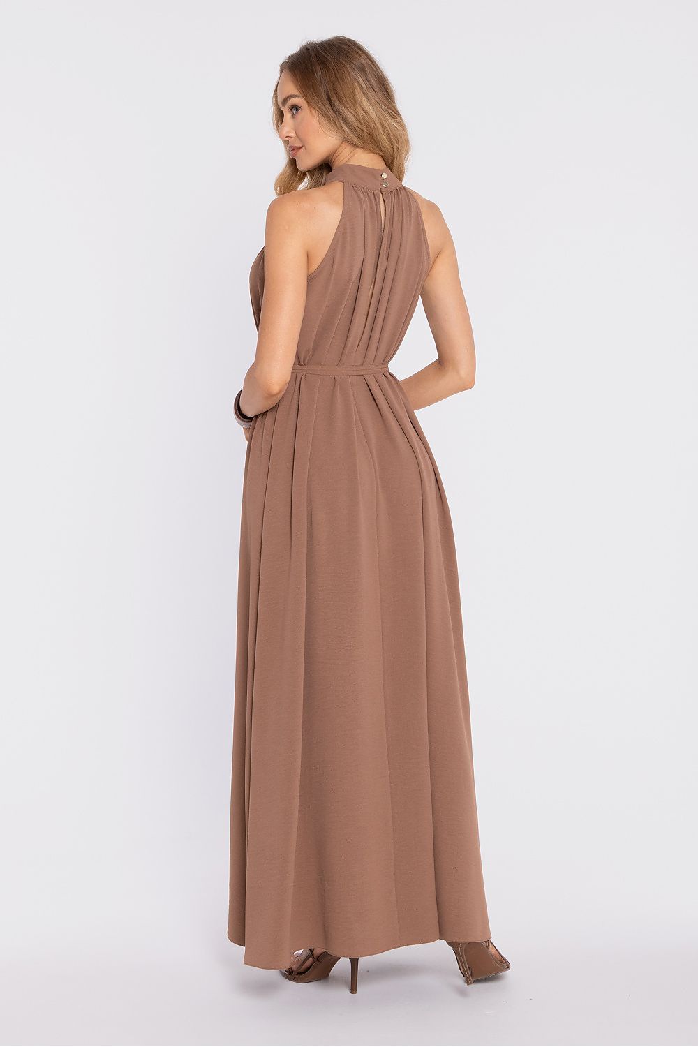 Woman wearing a long brown dress on a white background